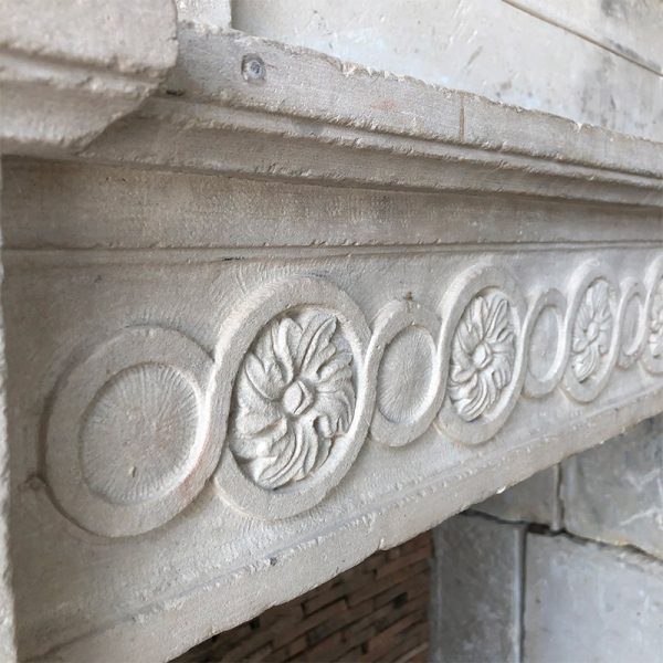Antique stone fireplace with floral freize lintel